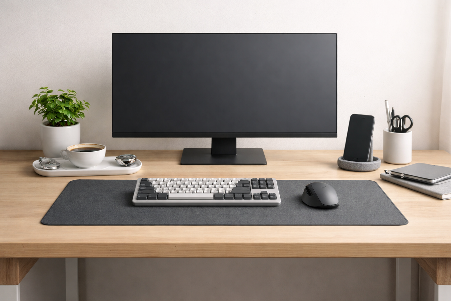 Clean desk setup with monitor, keyboard, mouse, and desk mat