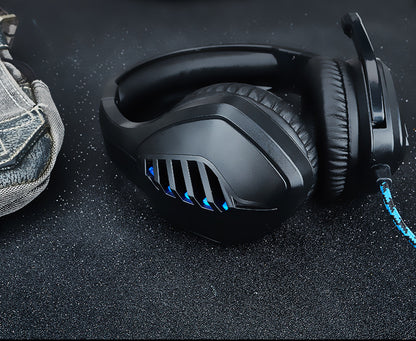 Black-blue wired gaming headset with microphone on a desk setup