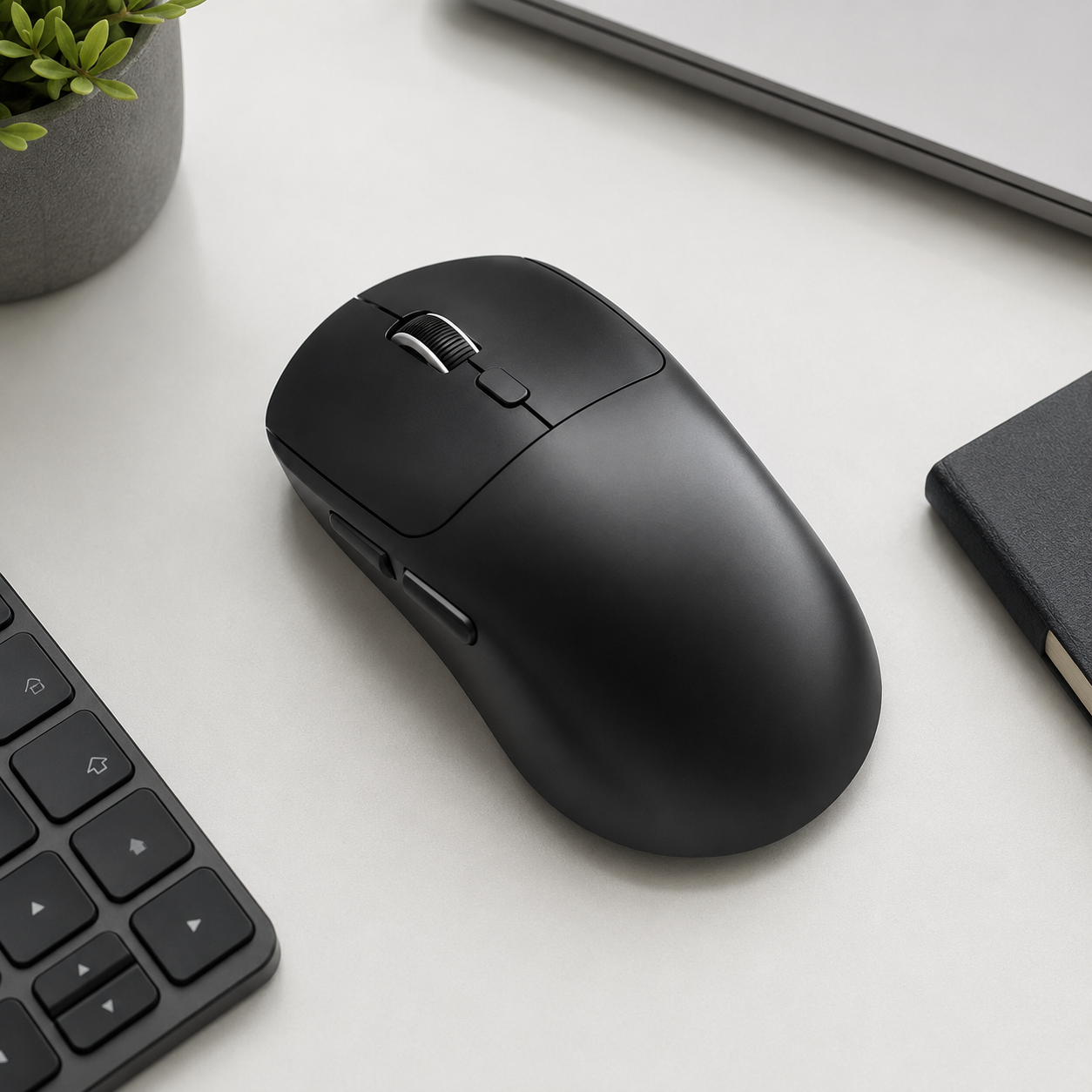 Black tri-mode wireless mouse on a clean desk setup