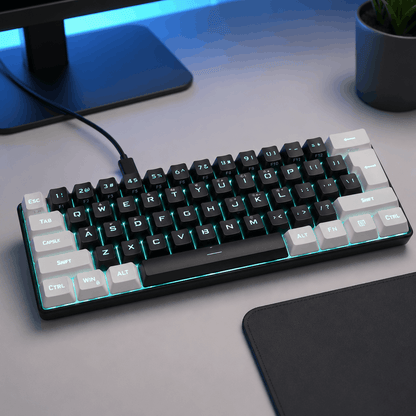 Black compact 61-key wired keyboard in a clean modern desk setup with blue accent lighting