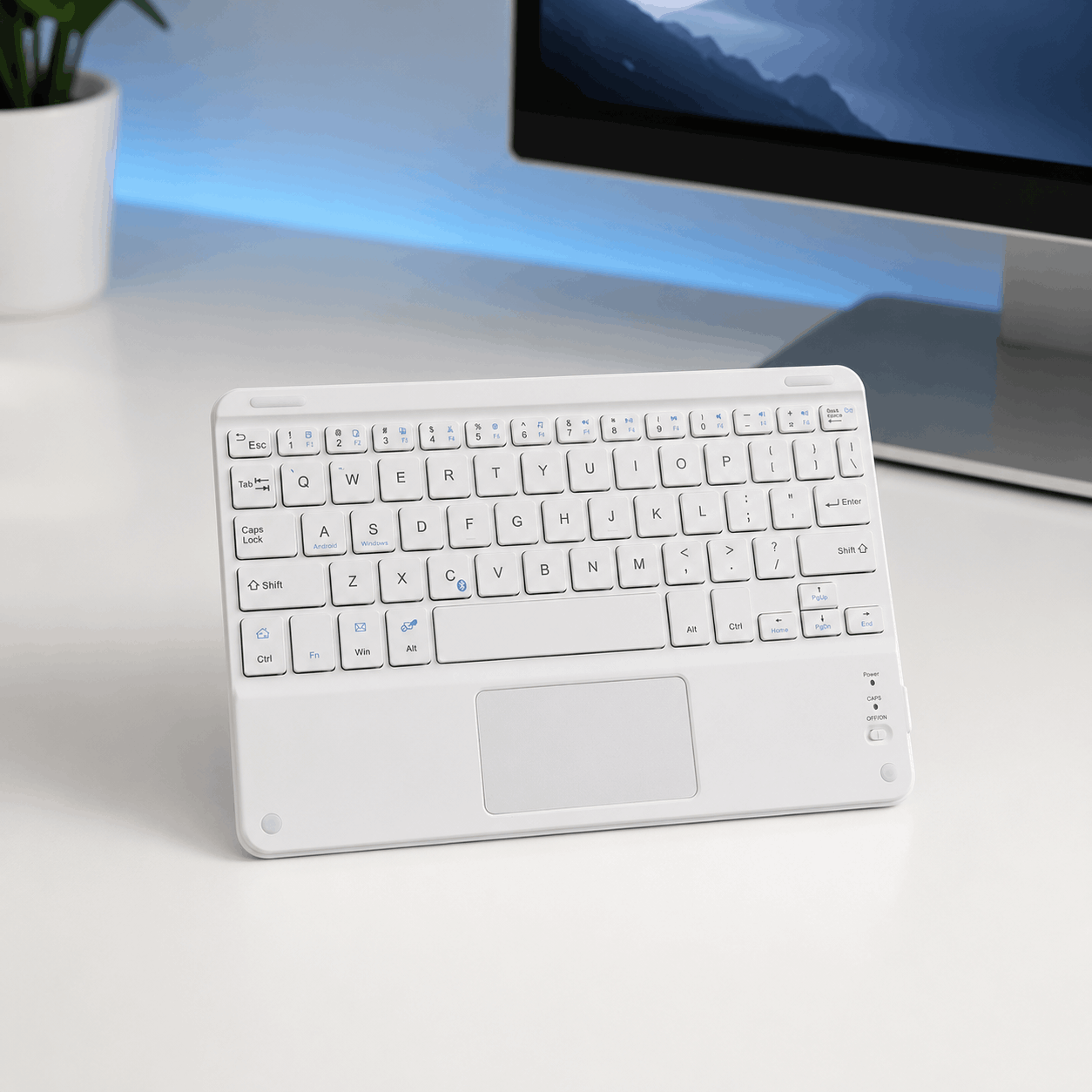White compact Bluetooth keyboard with built-in touchpad in a clean modern desk setup